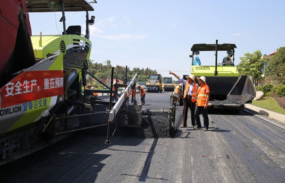 攤鋪機(jī)、壓路機(jī)等設(shè)備緊張有序運(yùn)行，高達(dá)170℃的瀝青混合料炙烤著公路人